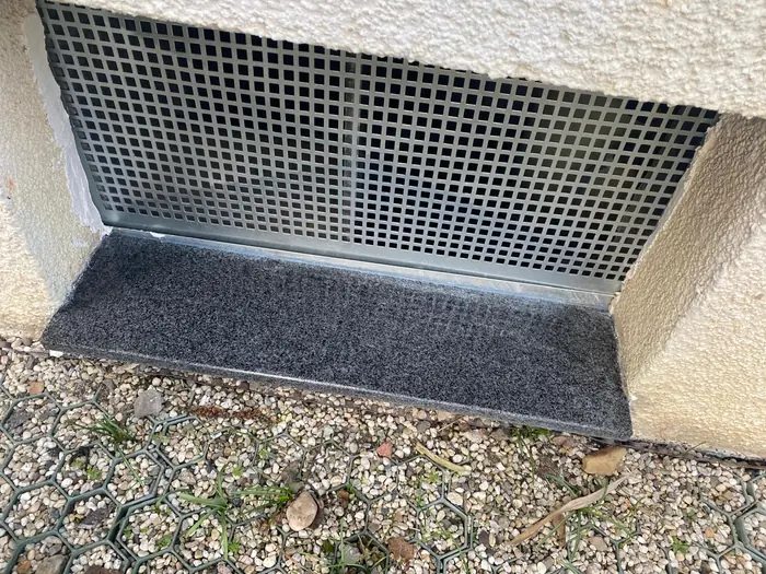 Neu verputzter, geschlossener Sockel unter dem Kellerfenstergitter