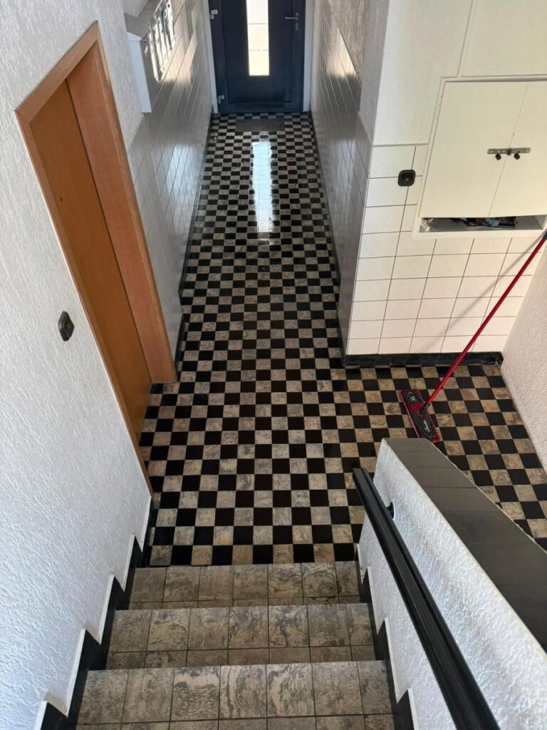 Gereinigtes Treppenhaus mit Fliesenboden, Wischmopp im Einsatz